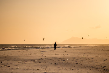 Fototapeta na wymiar Silhouette of man running on the beach during sunset