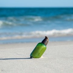 Green bottle on the beach