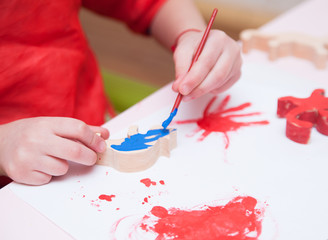 Baby painting a wooden cat
