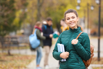 Fototapeta premium Teenage girl with backpack and books outdoors