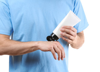 Man applying body cream on white background, closeup