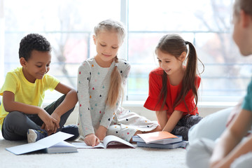 Cute children doing homework in classroom at school