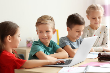 Fototapeta na wymiar Cute children doing homework in classroom at school