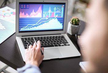 Man working at table in office, closeup. Financial trading concept