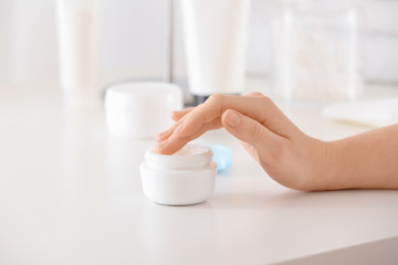 Woman with jar of body cream, closeup