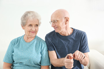 Senior people sitting on couch at home. Elderly care