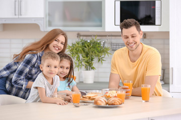 Obraz na płótnie Canvas Happy family having breakfast in kitchen