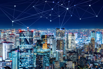 Business concept for information, communication , connection technology - panoramic modern city skyline, bird eye aerial night view under beautiful dark blue night sky in Roppongi Hill, Tokyo, Japan.