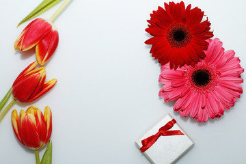 Card to the women's day. Flowers and gift on a white background