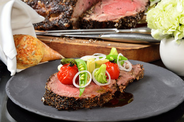 Rib eye steak with vegetables on black plate