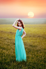 girl model in the open field at sunset, enigmatic smile
