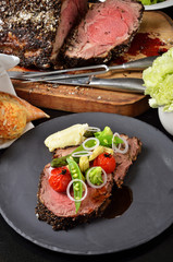 Rib eye steak with vegetables on black plate