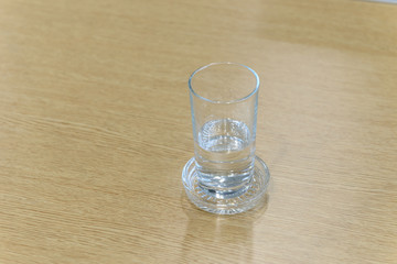 Glass of water on wooden table with copy space. Selective focus