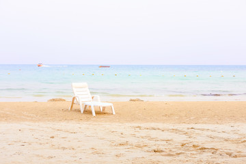 One beach chair on a white sand against the ocean view. Peaceful, calm place, relaxation concept. Vitage filter toned effect. Copy space for text