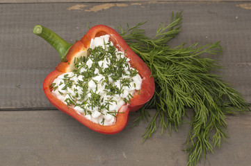 Bulgarian red pepper stuffed with curd and dill on a wooden board. 