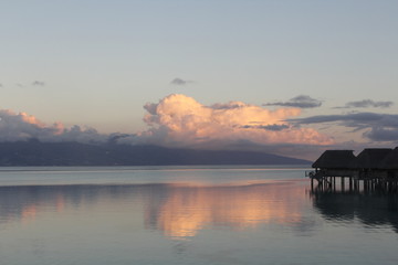 Sunset over over-water bungalows in Tahiti