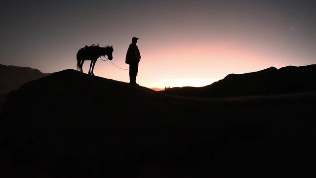 Horseman smoking and waiting for tourist to arrive in Mount Bromo at sunrise, Indonesia