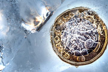 Frozen New British one pound sterling coin up close macro inside ice cubes