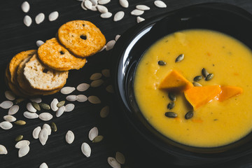 Pumpkin soup on a dark wooden background