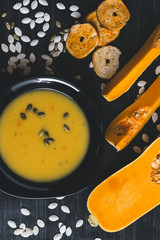 Pumpkin soup on a dark wooden background
