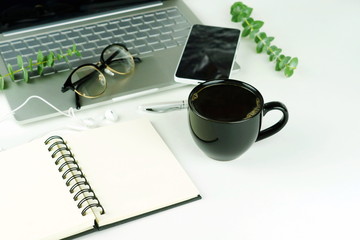 Top view of white office table with laptop, smartphone, cup of coffee and supplies. Top view with copy space. Flat lay.