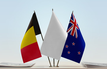 Flags of Belgium and New Zealand with a white flag in the middle