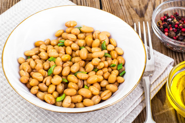 Canned white beans on wooden table