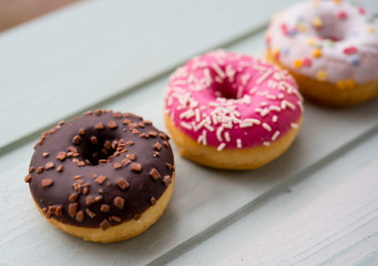 Colorful donuts on wooden background