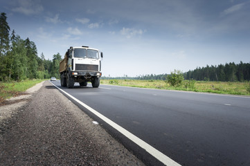 Fototapeta premium Transport ciężarowy na drodze o zachodzie słońca
