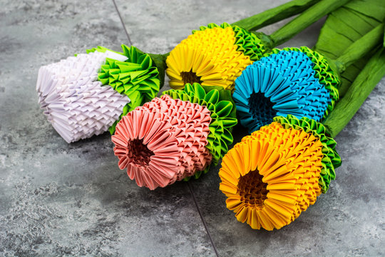 Origami handmade flowers on blue background