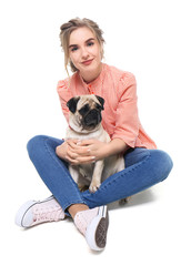 Obraz premium Young woman with cute pug dog on white background. Pet adoption