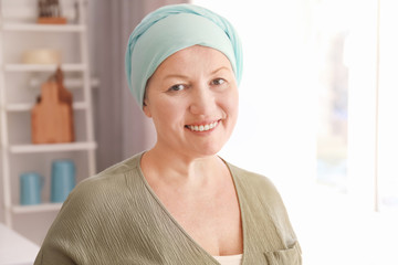Mature woman with cancer in headscarf indoors