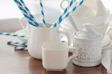 Set of white empty tableware with striped tubules