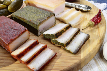 Smoked  bacon, pickles, onions ,garlic, paprika on a  wooden table - rustic style on blue vintage background.