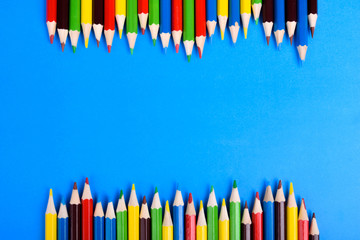 Colored pencils background.Color pencils isolated on white background.Close up. Many different colored pencils on blue background.Colorful pencil .Colorfull Macro shot of color pile pencil nibs
