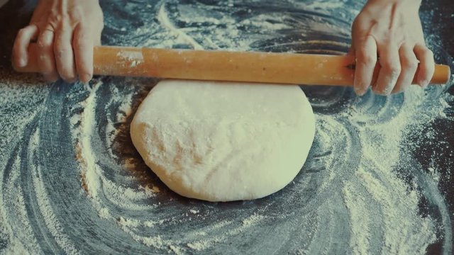 Rolling dough with rolling pin for baking