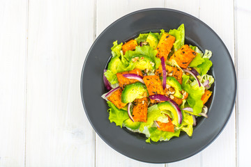Delicious salad with avocado, pumpkin, greens