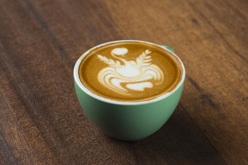 A Cup of hot latte art coffee on wooden table