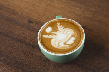 A Cup of hot latte art coffee on wooden table