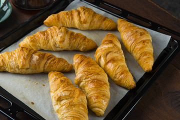 Fresh Croissants on rustic wooden background. Selective focus, horizontal.