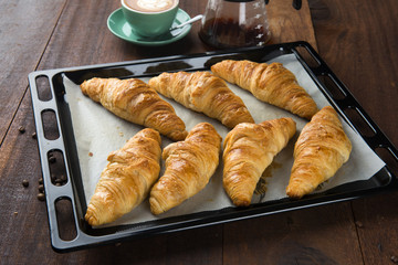Fresh Croissants on rustic wooden background. Selective focus, horizontal.