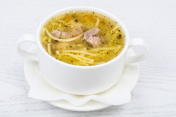 Chicken hot broth with vermicelli in white soup bowl