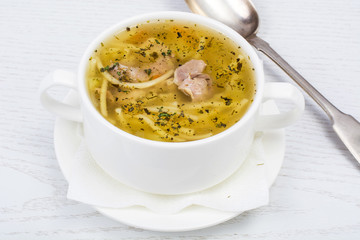 Chicken hot broth with vermicelli in white soup bowl