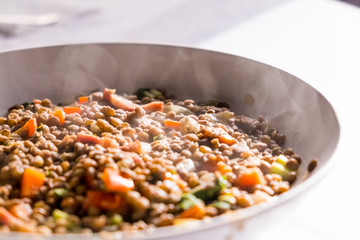 homemade dish of lentils with vegetables and carrots and smoke