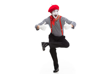 funny mime performing on one leg and showing thumbs up isolated on white