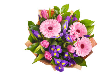 Bouquet of pink gerberas, violet irises and pink, crimson tulips in a package of paper. A holiday, a gift for a woman. Big and smart. View from above. Isolated.