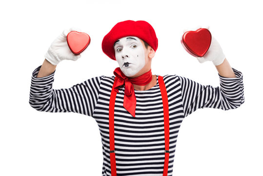 sad mime holding heart shaped gift boxes isolated on white, st valentines day concept