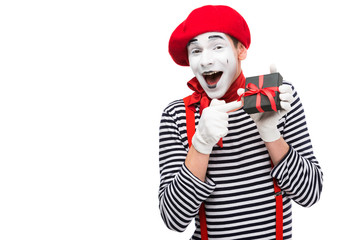laughing mime pointing on present box isolated on white