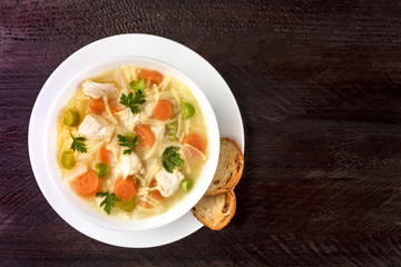 Chicken soup with noodles, overhead photo with copyspace