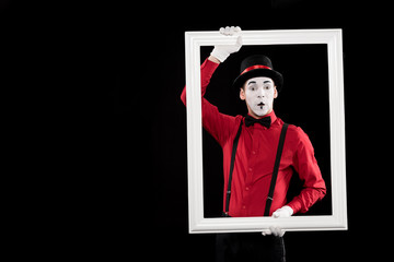 surprised mime holding frame isolated on black